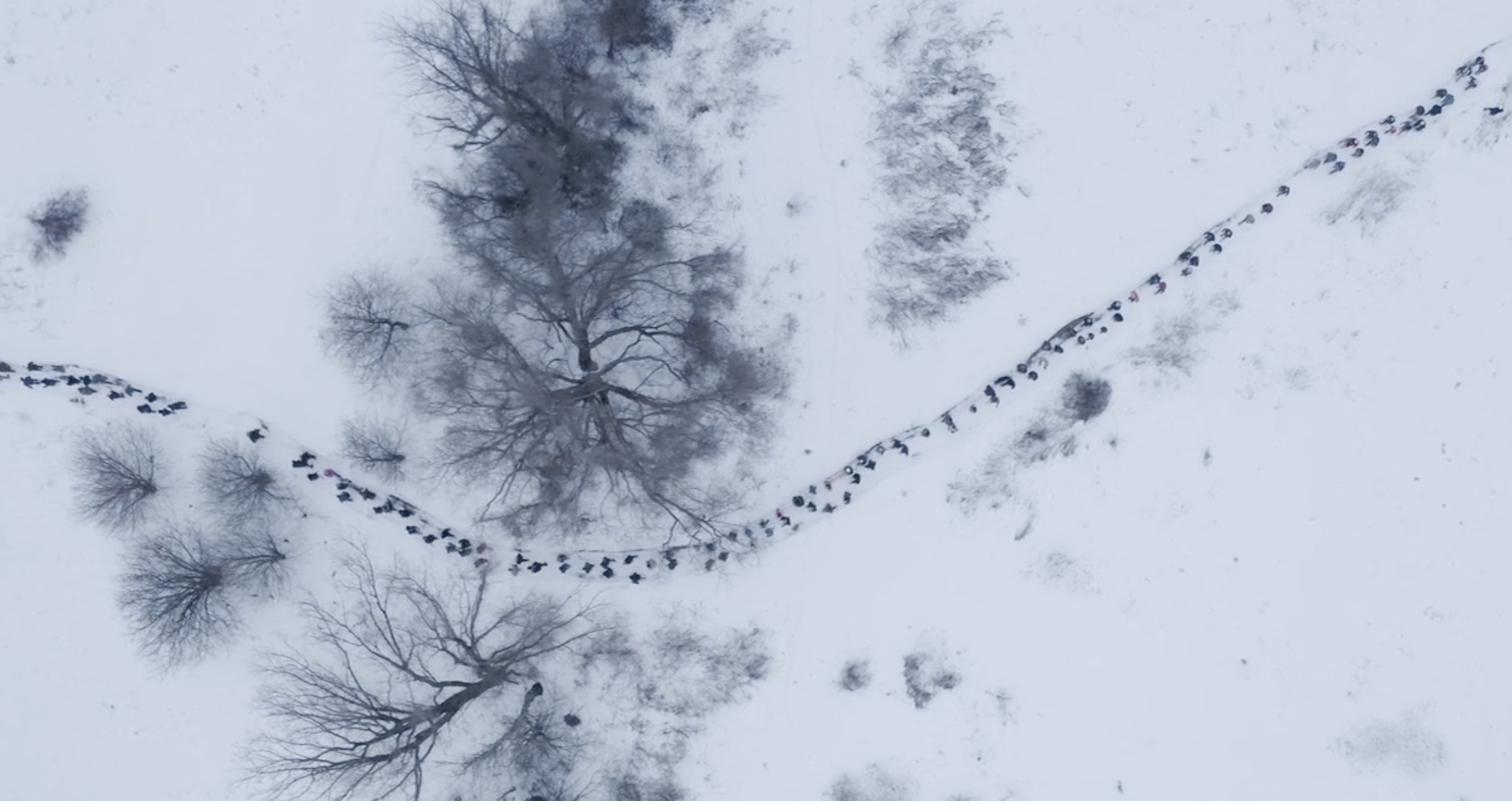 Aerial view of the Force of Nature soundwalk procession through the snow
